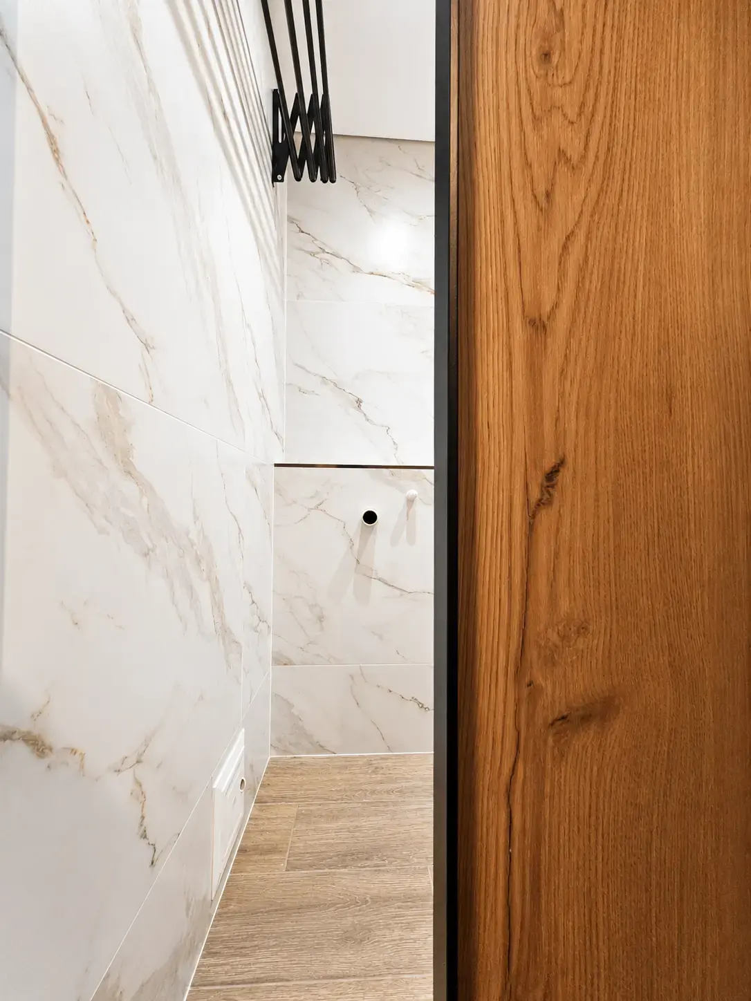 Pared de porcelanato tipo mármol junto a puerta de madera