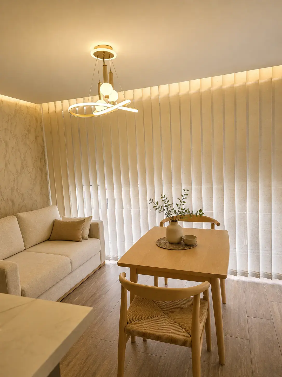 Sala comedor con luz cálida en el cielo raso y cortinas verticales