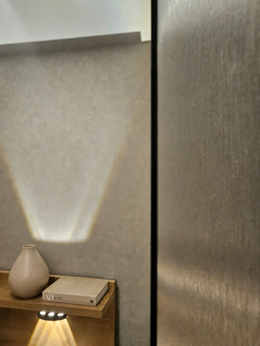 Aplique de luz sobre pared de tela y divisor oscuro