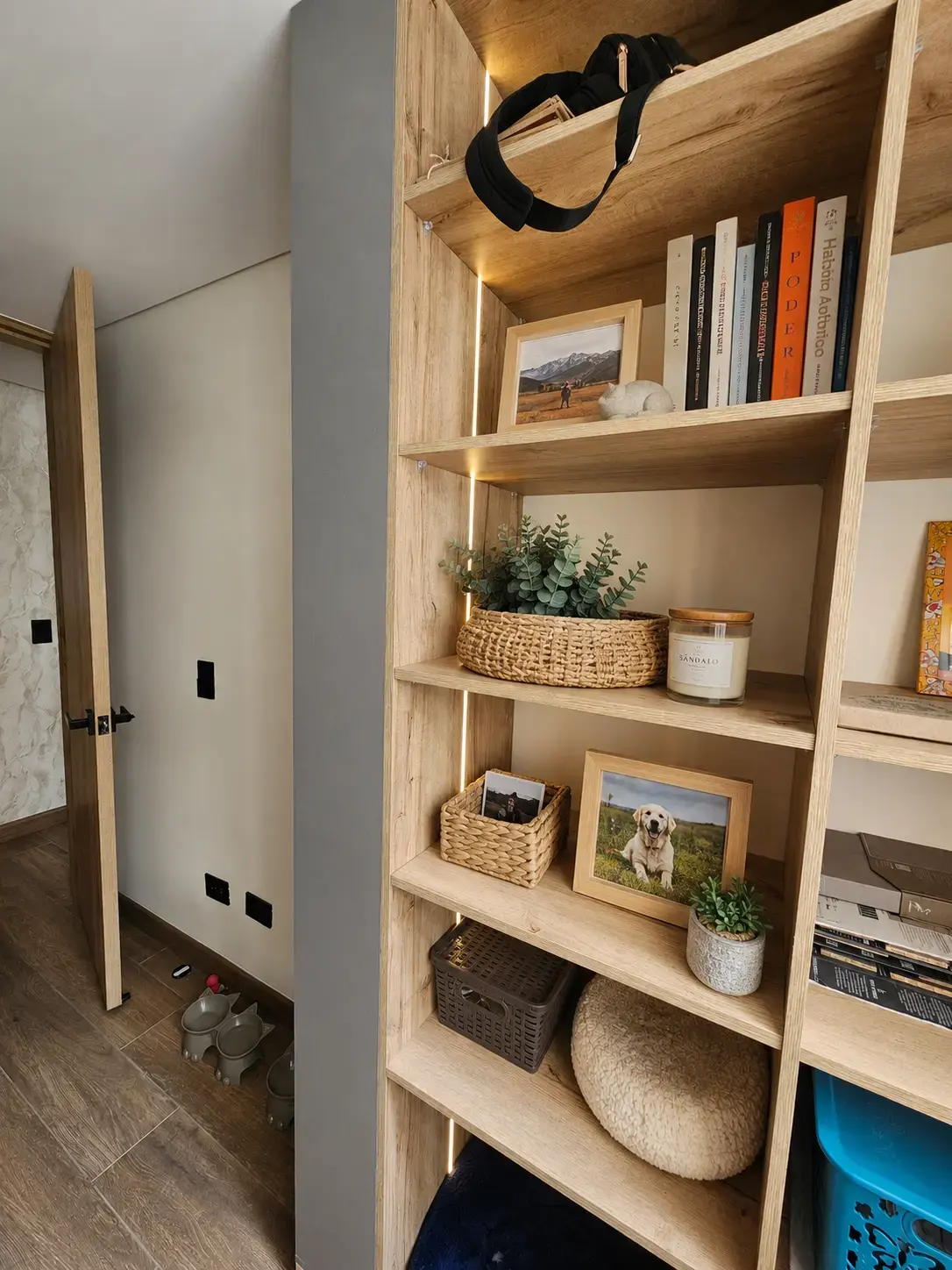 Biblioteca de madera con detalles grises y decoración en un apartamento