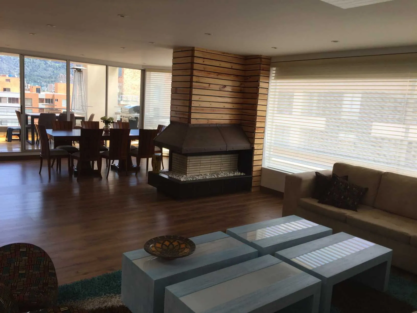 Sala comedor con chimenea y ventanales con vista a la ciudad