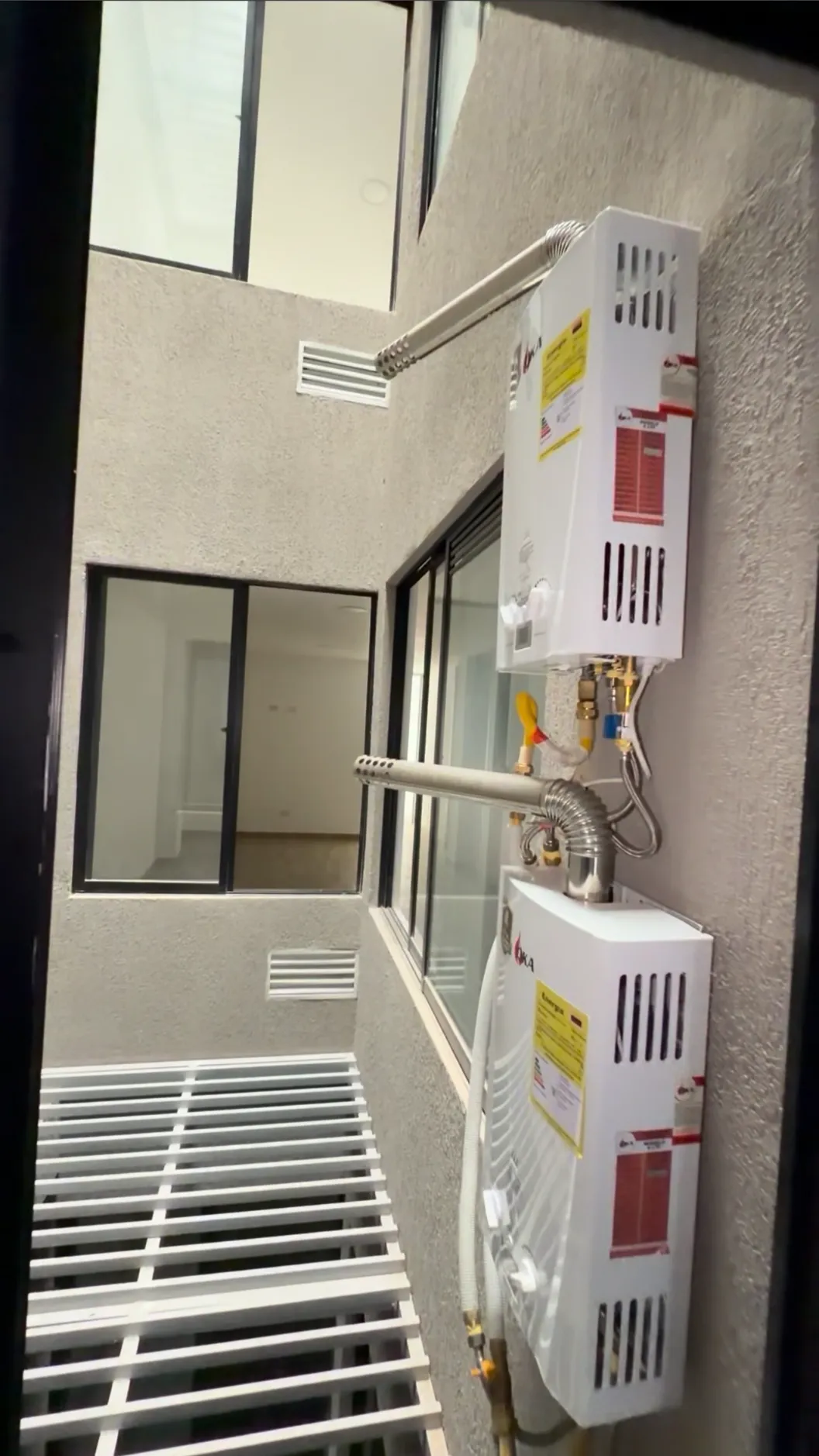Dos calentadores de gas en un patio con rejilla