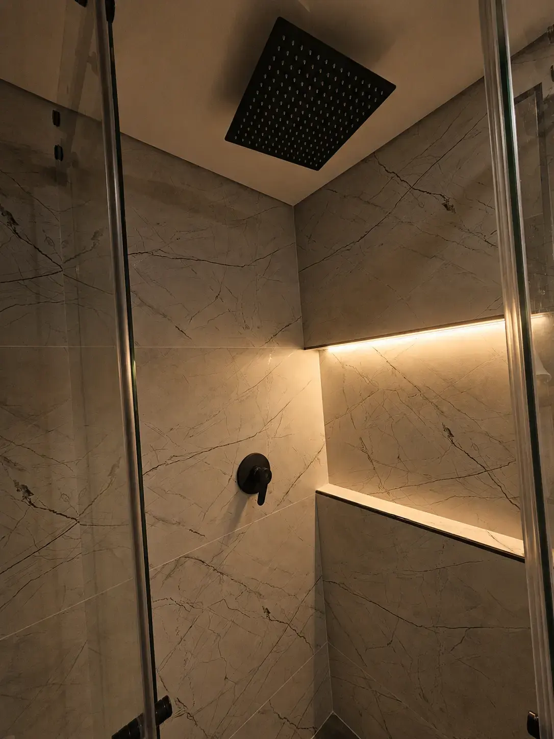 Ducha con regadera cuadrada negra y nicho con luz LED