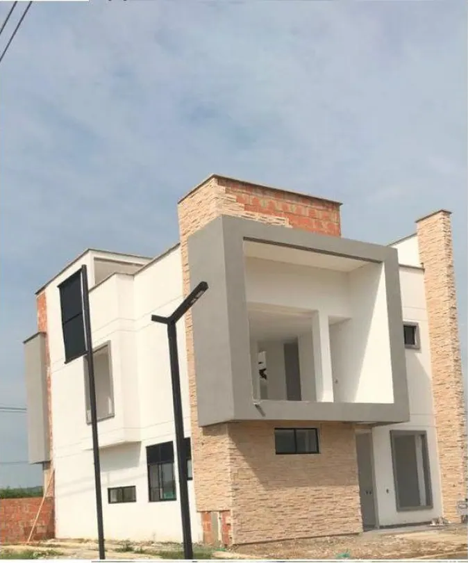 Casa de dos niveles con ladrillo a la vista, fachada blanca y balcón