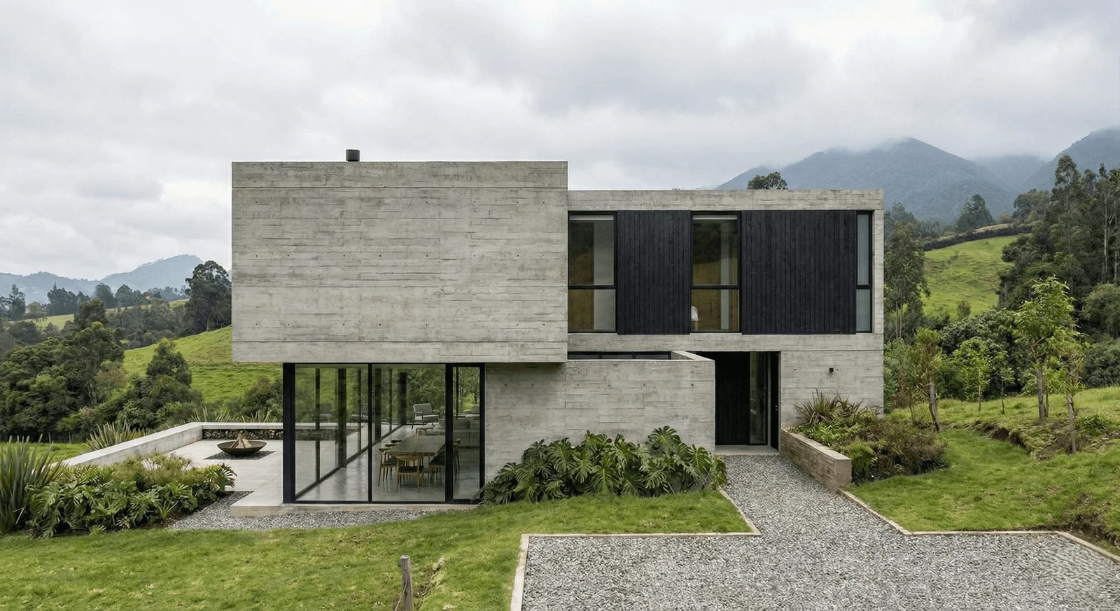 Casa de concreto aparente con ventanas negras y vista a las montañas
