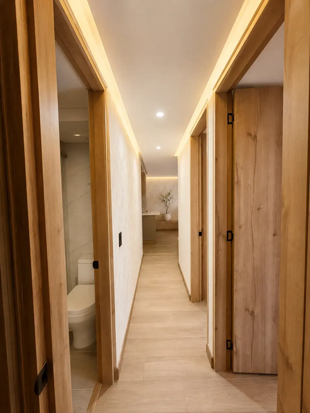 Pasillo con puertas de madera, luz LED y piso laminado claro