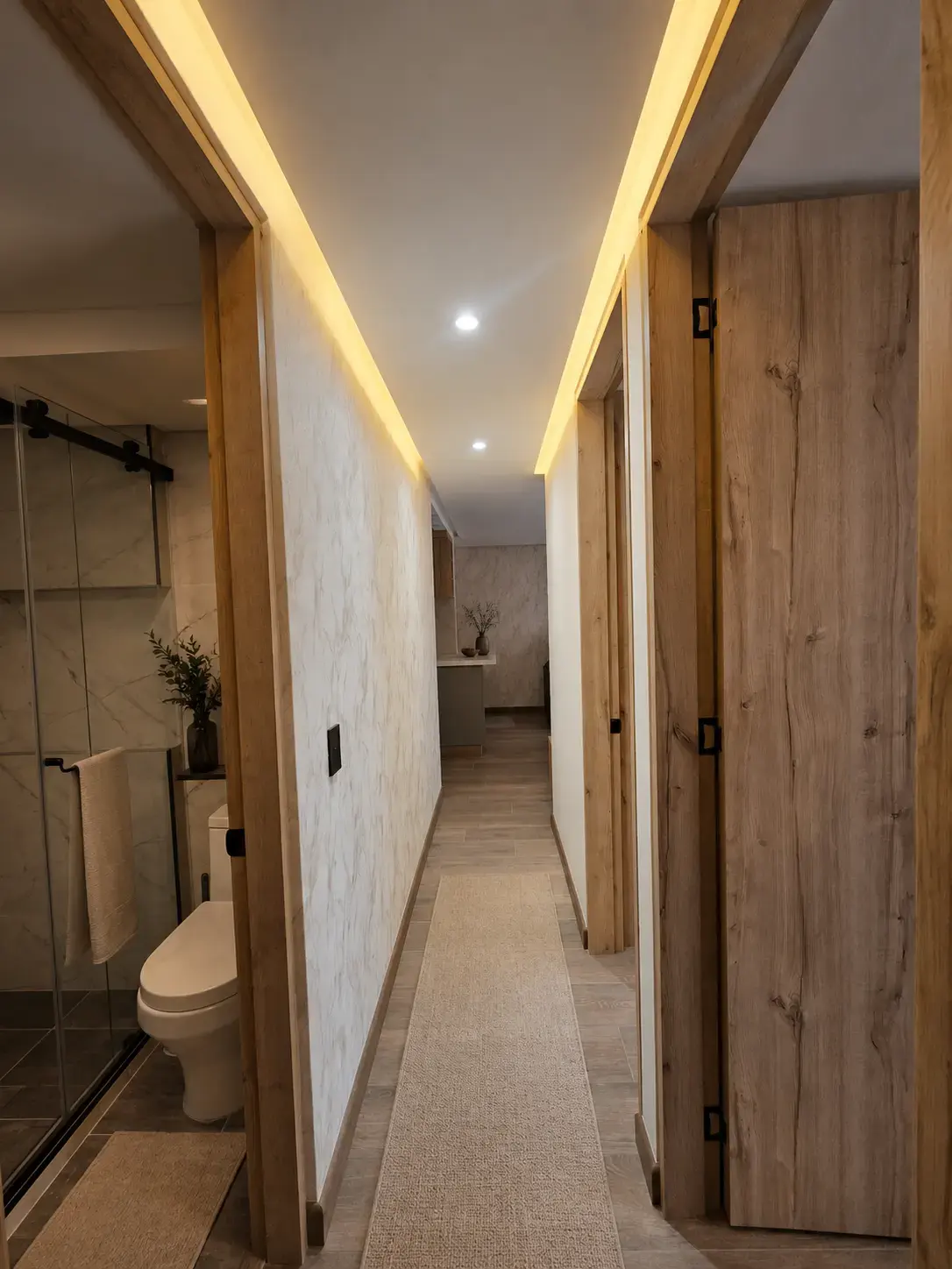 Pasillo con vista al baño, puertas de madera y luz LED