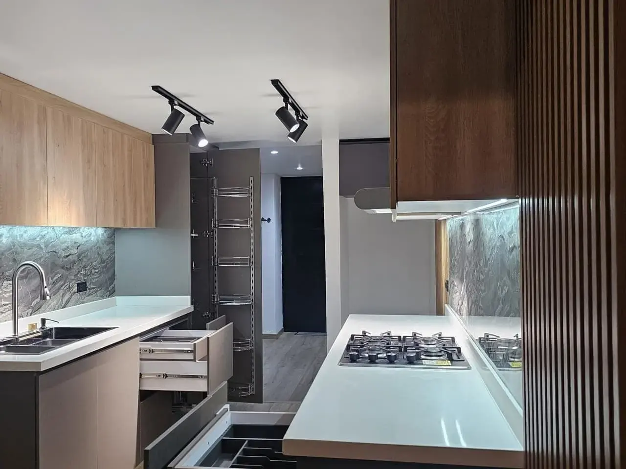 Cocina con lavaplatos, estufa de gas y panel de listones de madera