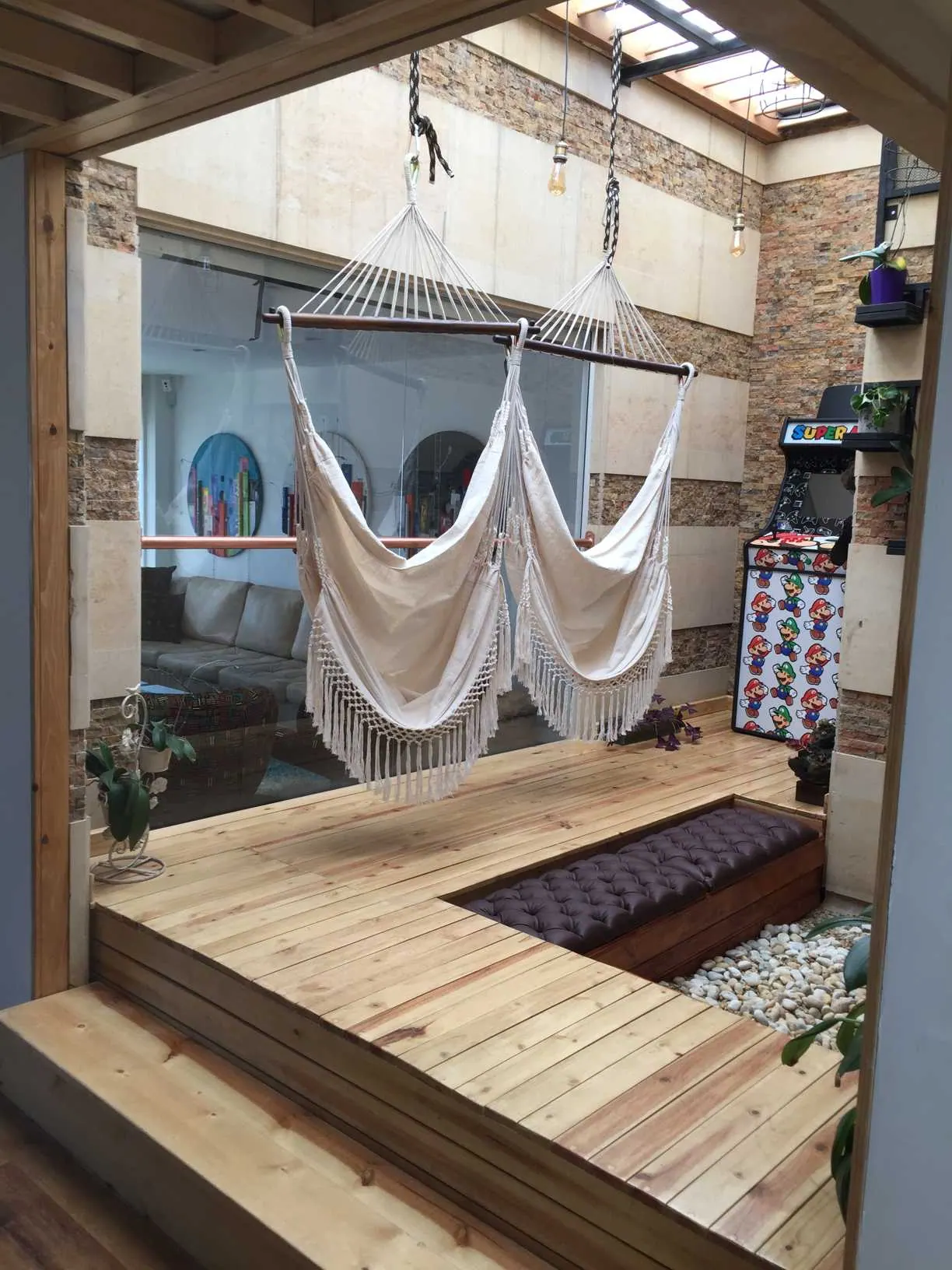 Deck de madera con hamacas en un patio con claraboya
