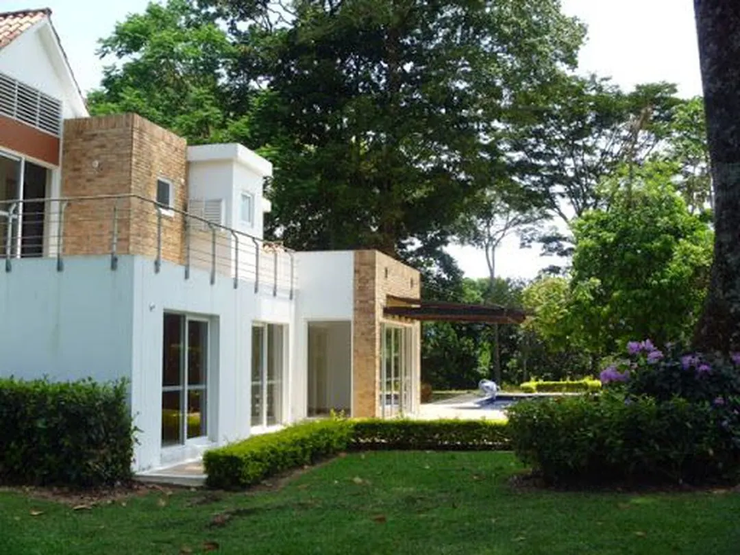 Casa blanca con balcón y jardín