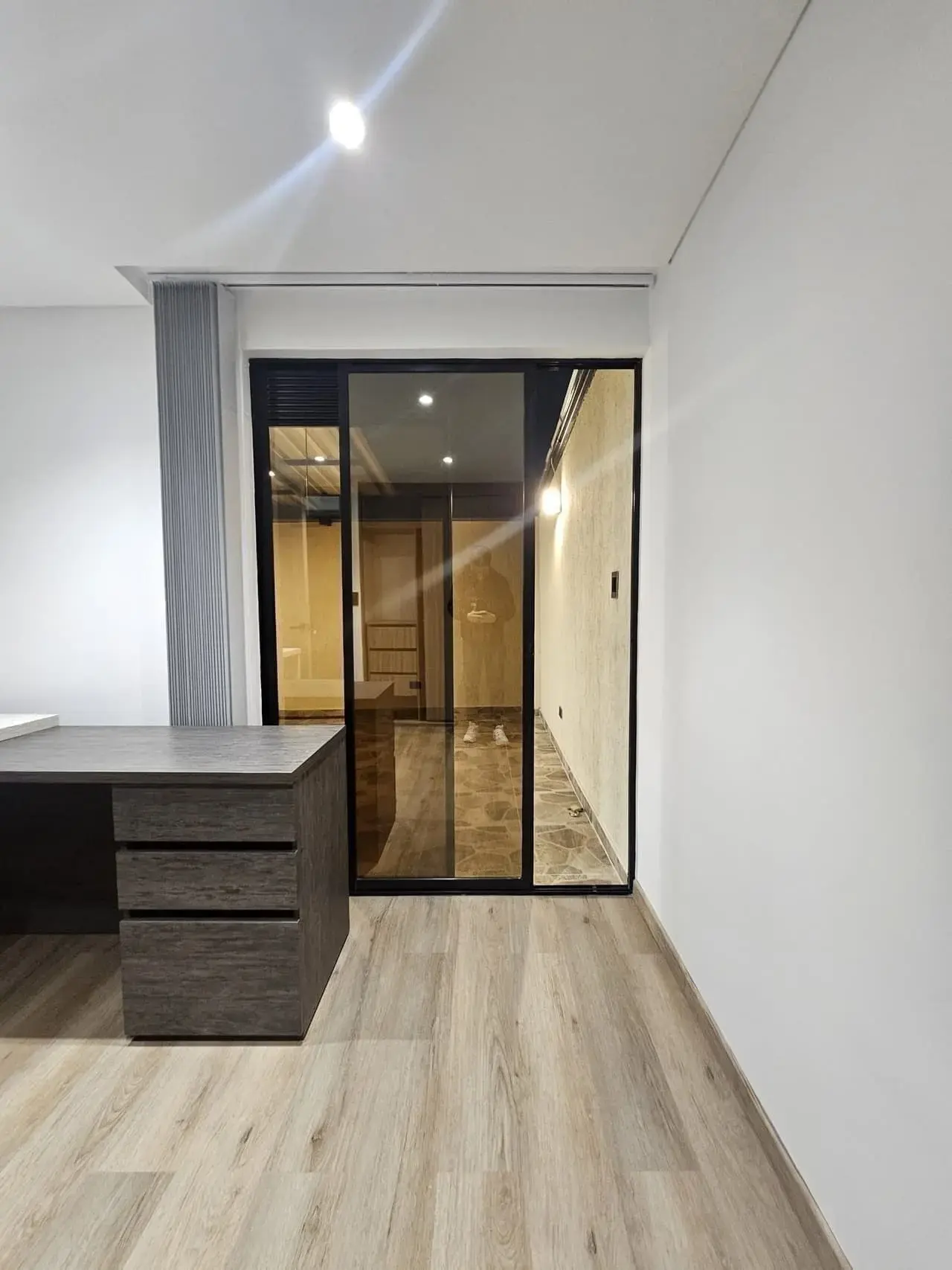 Estudio con escritorio de cajones y puerta corrediza de vidrio