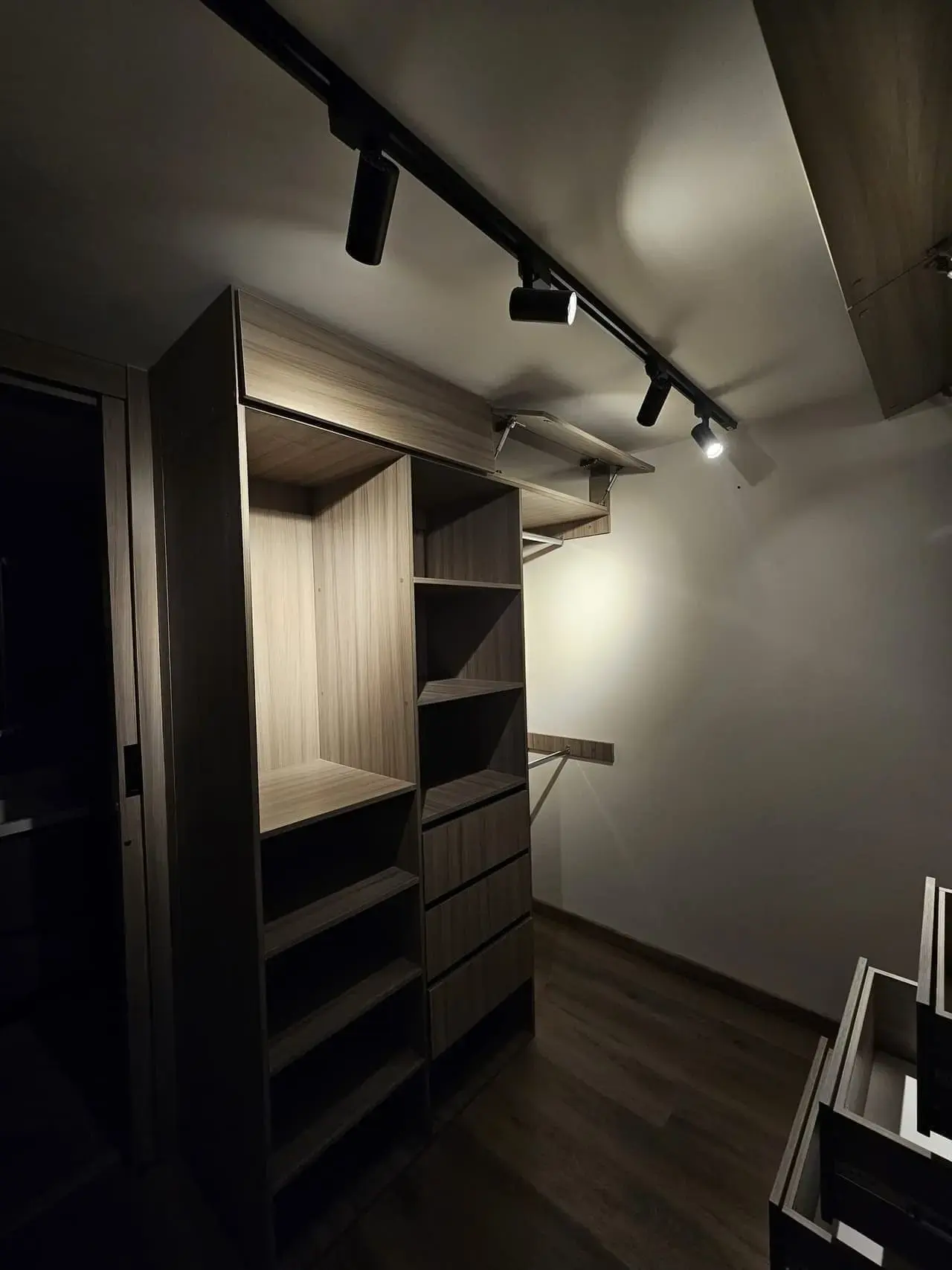 Closet con repisas y riel de luces en una habitación