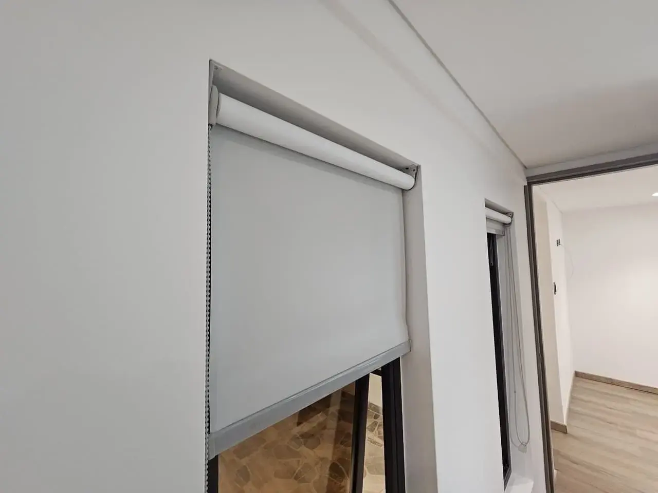 Persiana enrollable gris junto a una ventana