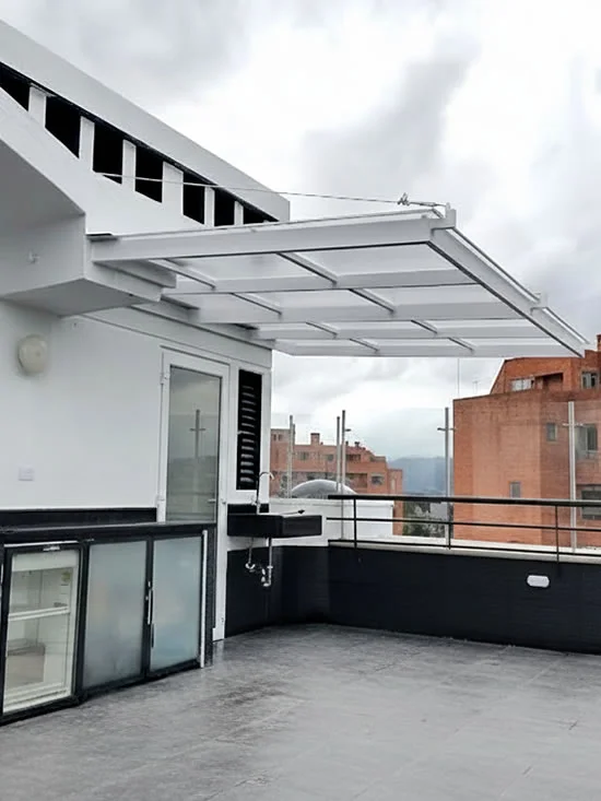Cubierta blanca en voladizo sobre la terraza de un edificio, con una cocina exterior y vista a la ciudad