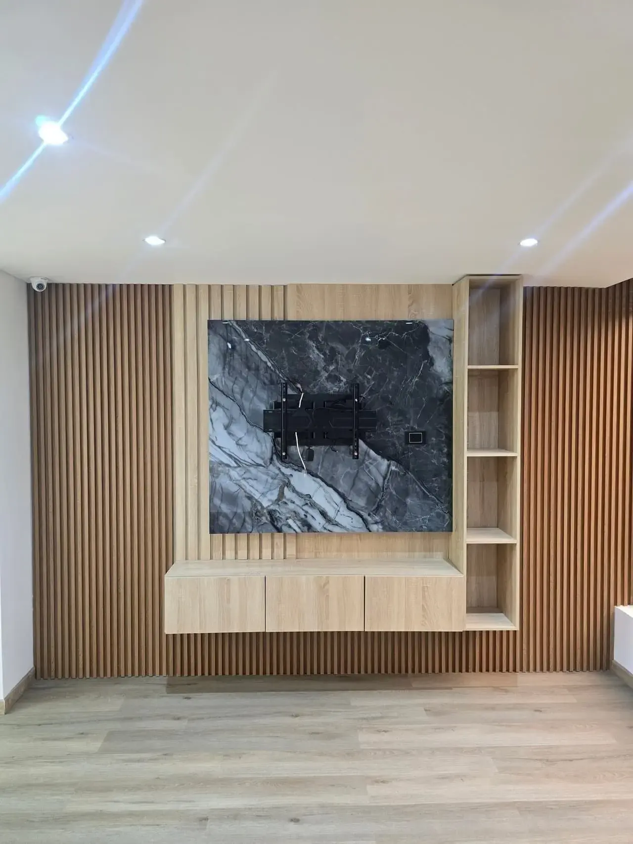 Panel de listones de madera con obra de arte y repisas